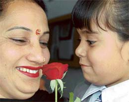 Mothers Day: A child offers a rose to his mother in city. 