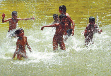 Children splash around in water to beat the heat at the Boat Club in the Capital. 