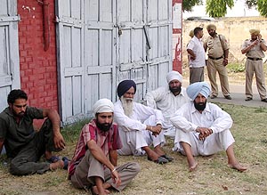 Relatives of Nawab Singh, security guard of Mr Bir Devinder Singh, sit outside the Government Rajindra Hospital in wait of the body for cremation in Patiala on Saturday. 