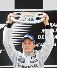 McLarens Formula One driver Kimi Raikkonen of Finland holds the trophy after winning the Spanish Grand Prix in Montmelo, near Barcelona, on Sunday