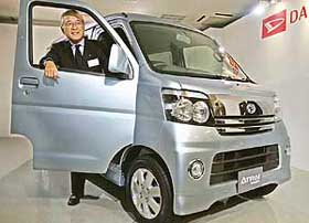 Japans automaker Daihatsu executive Katsuyuki Kamio poses with the new roomy SUV, Atrai Wagon, equipped with a 660 cc turbo-charged engine at the companys showroom in Tokyo on Monday