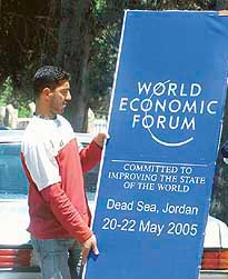 A worker holds a banner of the World Economic Forum in Amman on Monday
