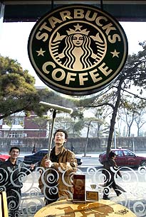 Staff clean the storefront window of an American chain Starbucks coffee shop on Monday in Beijing