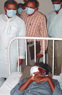 Delhi Health Minister Yoganand Shastri looks at a patient suspected of having bacterial meningitis at the Lok Nayak Jai Prakash Hospital in the Capital on Monday.