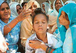 Ten-year-old Sukhwinder Singh, son of Swaran Singh who was killed by robbers, being consoled by his relatives at Mastgarh village near Chandigarh. 