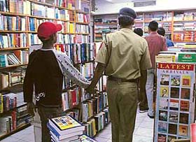Walking free: One of the 15 inmates of Juvenile Remand Home, Sector 15, goes around Capital Book Store with an escort police officer