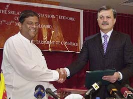 Sri Lankan Minister Commerce Minister Jeyaraj Fernandopulle (L) exchanges signed trade agreements with his Pakistani counterpart Humayun Akhtar Khan in Colombo, Sri Lanka, on Friday. A Free Trade Agreement between Sri Lanka and Pakistan, signed in February, will be made operational from June 12, 2005, allowing duty-free trade of products between Sri Lanka and Pakistan.