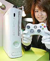 A Microsoft employee displays the console and wireless controller of Microsofts next generation video game console, Xbox 360, during a press preview at a Tokyo theatre on Friday. Microsoft will put it on the market at the end of the year.