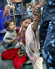A mother holds on to her child as she cries while defying police arrest at Bhotahiti road in Kathmandu on Friday