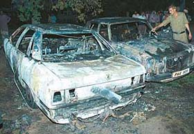 The two cars which caught fire are inspected by the police in the Sector 44 park in Chandigarh