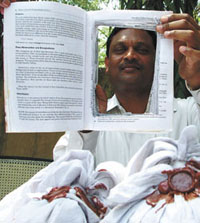 A policeman showing the book and heroin seized from the accused in the Capital