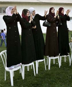 Palestinian women applaud local leaders of the Islamic militant group Hamas during a rally