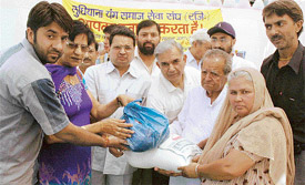 Activists of the Ludhiana Young Samaj Sewa Sangh handing over packets of ration to needy women