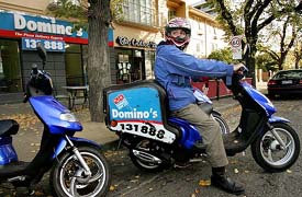 A Dominos Pizza delivery boy prepares to speed into the traffic with his order in the pizza-saturated suburb of Carlton in Melbourne on Monday as Dominos becomes the first pizza company to list on the Australia Stock Exchange. 