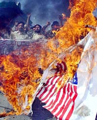 Pakistani shia Muslim activists of the Imamia Student Federation burn a US flag during a protest in Peshawar