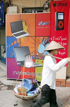 A street vendor walks past a computer shop in Hanoi on Tuesday. Vietnams computer industry is facing a serious shortage of IT professionals.