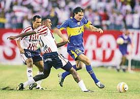 Andres Guglielminpietro of Boca Juniors evades Cristian Racero of Atletico Junior during a qualifying match for South Americas Libertadores Cup at Barranquilla in Colombia