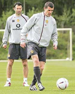 Manchester United captain Roy Keane is watched by Ryan Giggs during training at Carrington
