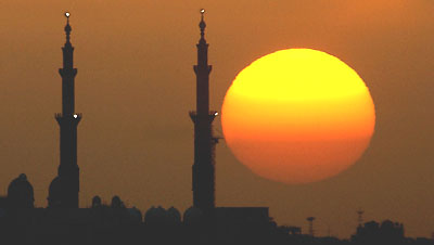 The sun sets behind a mosque in Abu Dhabi on Wednesday