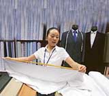 A textile trader measures cloth at a market in Beijing on Thursday.