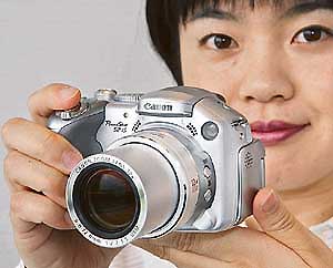 Japans camera giant Canon employee Kyoko Arimura displays a new digital camera, PowerShot S2 IS, in Tokyo on Thursday