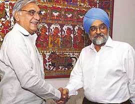 Deputy Chairman of Planning Commission Montek Singh Ahluwalia and Haryana Chief Minister Bhupender Singh Hooda pose in front of photographers before the Annual Plan meeting in New Delhi on Thursday