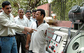 A Delhi Police sleuth showing the machine which was used in making fake drugs in the Capital on Thursday
