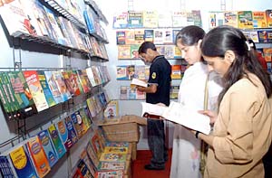 Girls see the books at a fair organised by the National Book Trust and the Himachal Education Department in Shimla on Sunday.