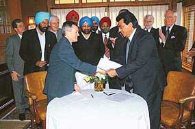 Mr Avtar Henry and Mr Eric Cline exchange documents after signing biotech MoU at Saskatoon, Canada, in the presence of Punjab Chief Minister Amarinder Singh and his delegation.