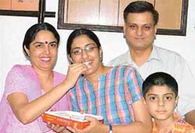 Akriti of DAV Public School being offered sweets by her mother.