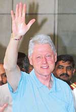 Former US President Bill Clinton waves as he arrives in New Delhi on Wednesday.