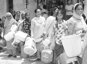 Women queue up for procuring drinking water from a water tanker at Deep Nagar in Bathinda