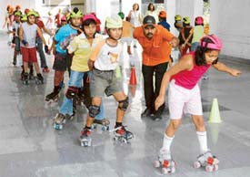 Children skating their way through a hot day in city. 
