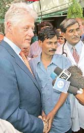 Former US President Bill Clinton shakes hands with an HIV positive man in New Delhi on Thursday. 