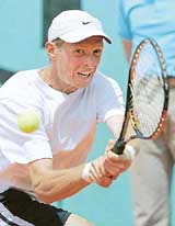 Nikolay Davydenko of Russia hits a backhand shot during his match against Olivier Rochus of Belgium in the second round of the French Open at Roland Garros on Thursday
