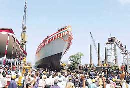 Workers and onlookers wave as the Indian Navy's newly built frigate 'Sahyadri' sails into the sea after its launch in Mumbai on Friday. ' Sahyadri', which has been built in the Mazagon Docks, is the third and final frigate of Project-17 class stealth frigates.
