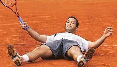 Argentinas Jose Acasuso falls on the court after defeating Andy Roddick of the US 