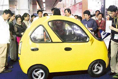 A mini-electric car attracts visitors at the Eighth Beijing International Science Industry Exposition in Chinese capital city of Beijing