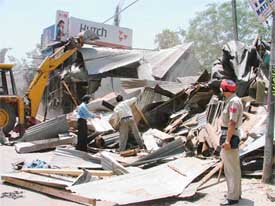 Temporary structures being demolished by officials of the Ludhiana Municipal Corporation near the Clock Tower