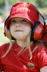 A young supporter of the Ferrari Formula One team wears ear protectors before a practice session