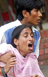 A student of Dhaka University helps his classmate after she was injured during a protest in Dhaka