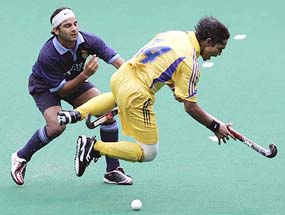 Malaysias Azlan Misron (right) trips after being tackled by Indias Inderjeet Singh during a match at the 14th Sultan Azlan Shah Cup Hockey Tournament in Kuala Lumpur on Sunday.