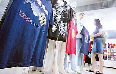 A woman walks past a display of T-shirts for sale at a deserted Friendship Store in Beijing