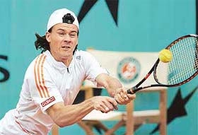 Guillermo Coria of Argentina plays a backhand shot during his match against Nikolay Davydenko of Russia in the fourth round of the French Open at Roland Garros