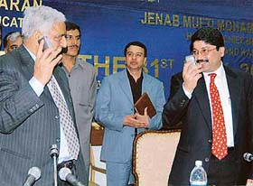 Chief Minister Mufti Mohammad Sayeed and Information Minister Dayanidhi Maran talk on cellphones during the function organised in Srinagar