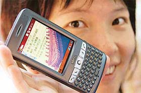 A woman displays the latest smart PDA phone during the Computex Taipei at World Trade Center, Taiwan