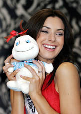 Newly crowned Miss Universe 2005 Natalie Glebova from Canada smiles while holding a mascot during a visit at the tourist ministry offices for a campaign to promote tourism in Thailand on Wednesday.