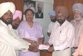 Mrs Lakhwinder Kaur Garcha, OSD to the Chief Minister Punjab, gives cheques to heads of schools and village panchayats in Mohali.