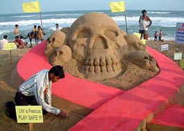 Renowned sand artist Sudarshan Patnaik creates a symbolic gesture during an HIV/AIDS awareness campaign