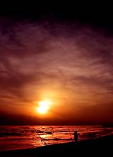 A fisherman prepares to cast his line at sunset along Sant'Agostino seafront, near Rome, on Wednesday